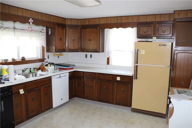 kitchen with dark brown cabinets, white appliances, and sink