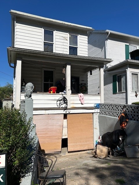 back of property featuring covered porch