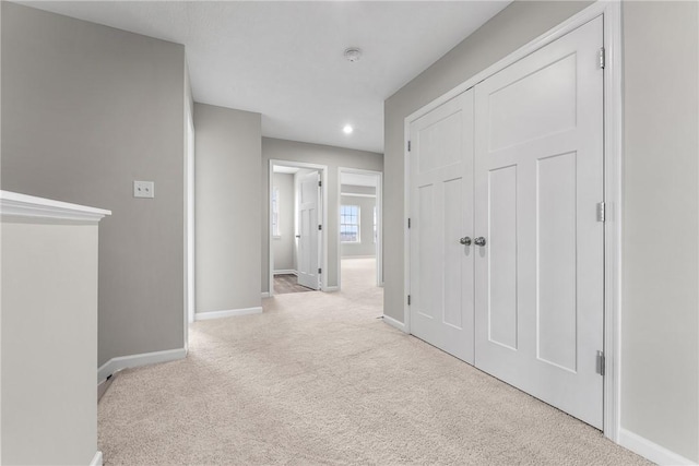 hallway with light colored carpet