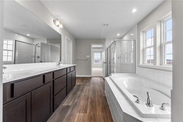 bathroom with hardwood / wood-style floors, plenty of natural light, and independent shower and bath