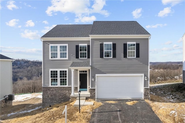 view of front of property featuring a garage and central AC unit