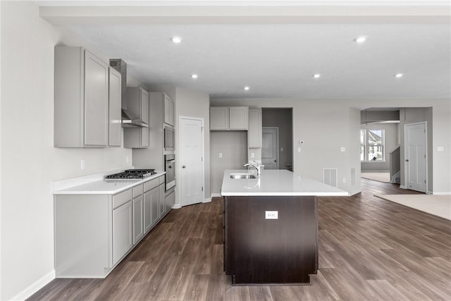 kitchen featuring a kitchen island with sink, sink, stainless steel appliances, and dark hardwood / wood-style floors