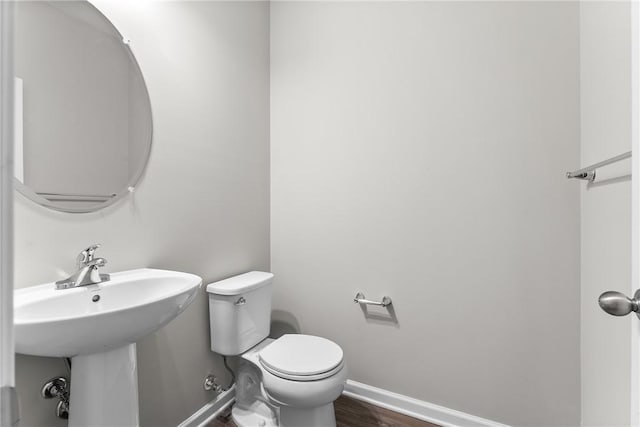 bathroom featuring sink, hardwood / wood-style floors, and toilet