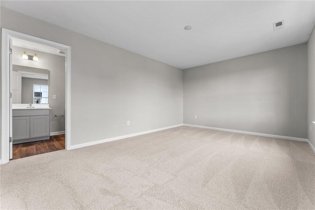 carpeted spare room with sink