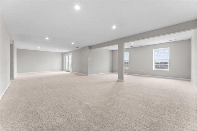 basement featuring a wealth of natural light and light colored carpet