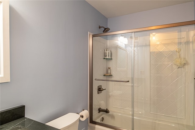 bathroom with enclosed tub / shower combo and toilet