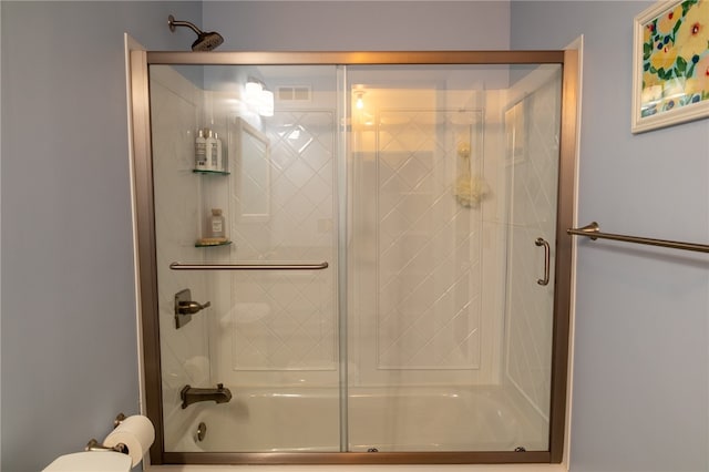 bathroom with combined bath / shower with glass door