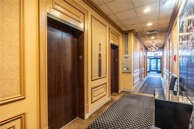 corridor with carpet floors, ornamental molding, and elevator