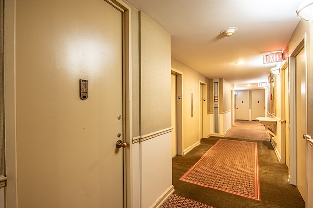 corridor featuring dark colored carpet