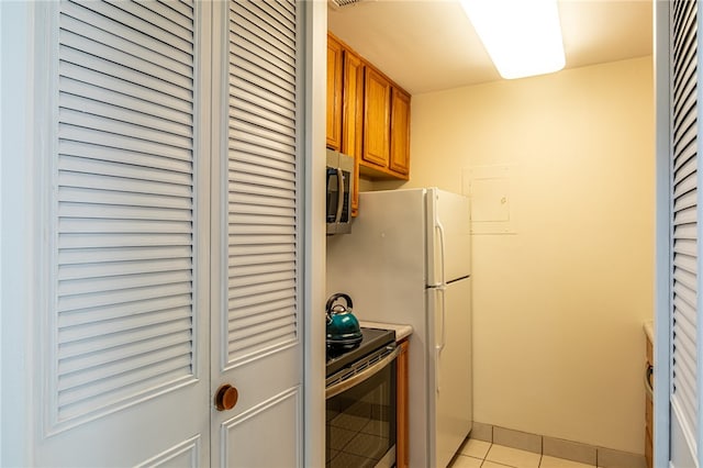 kitchen featuring stainless steel appliances and light tile patterned floors