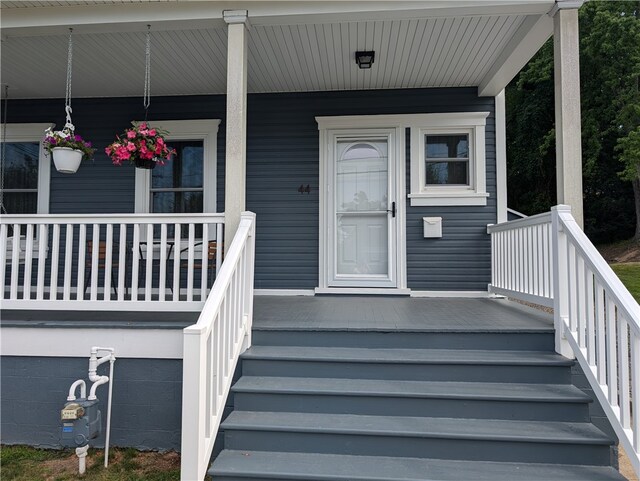 view of exterior entry featuring covered porch