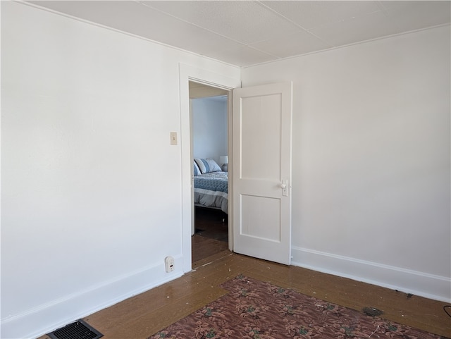 unfurnished room with dark wood-type flooring