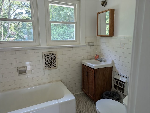 bathroom featuring tile patterned floors, heating unit, toilet, a bathtub, and vanity