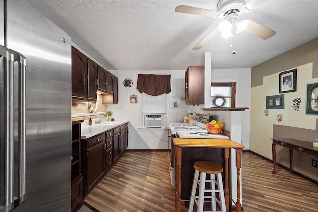 kitchen featuring sink, dark brown cabinets, high end fridge, dark wood-type flooring, and electric range