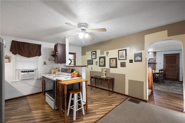 kitchen featuring a textured ceiling, dark hardwood / wood-style floors, cooling unit, electric stove, and dark brown cabinetry