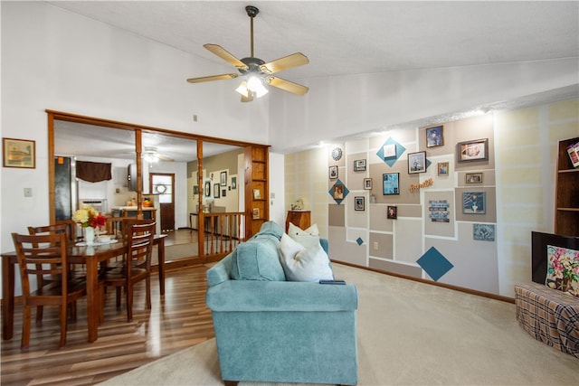 living room featuring wood-type flooring, vaulted ceiling, and ceiling fan