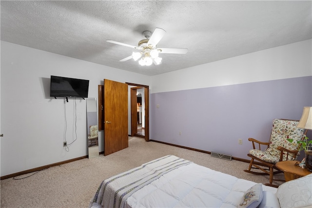 bedroom featuring a textured ceiling, ceiling fan, and light colored carpet