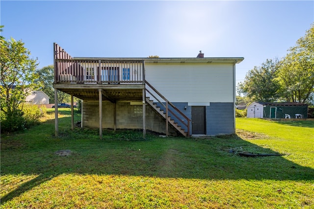 back of house with a lawn, a storage shed, and a wooden deck