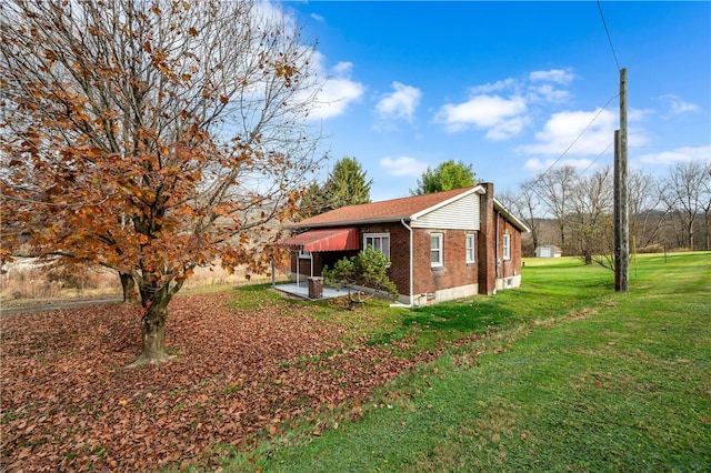 view of side of home featuring a lawn and a patio