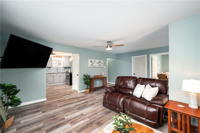 living room featuring ceiling fan and light hardwood / wood-style floors