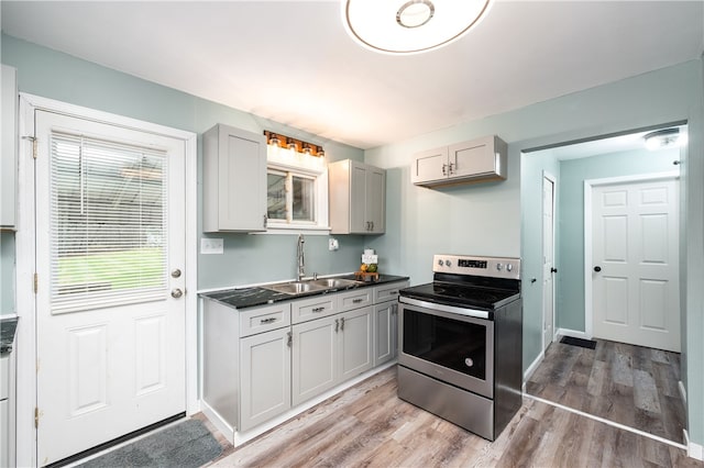 kitchen featuring sink, light hardwood / wood-style floors, gray cabinetry, and electric stove