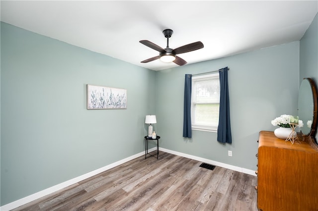 interior space with ceiling fan and wood-type flooring