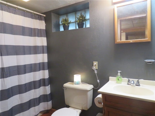 bathroom featuring vanity, toilet, and walk in shower