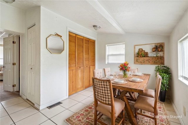 dining space featuring vaulted ceiling and light tile patterned floors