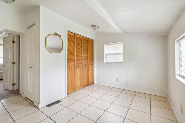 unfurnished bedroom featuring light tile patterned flooring, a closet, and a textured ceiling