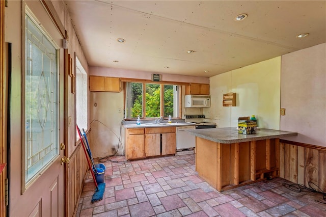 kitchen with sink, wooden walls, kitchen peninsula, and white appliances