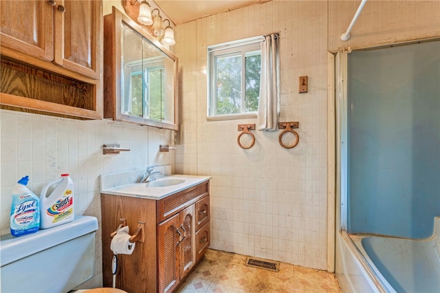 full bathroom featuring tile walls, vanity, tile patterned flooring, toilet, and  shower combination