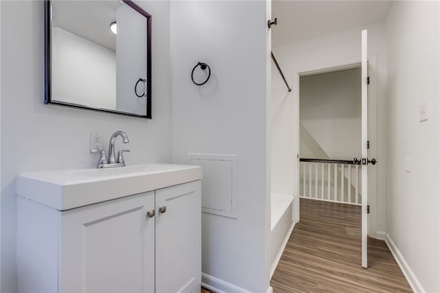 bathroom with bathtub / shower combination, hardwood / wood-style floors, and vanity