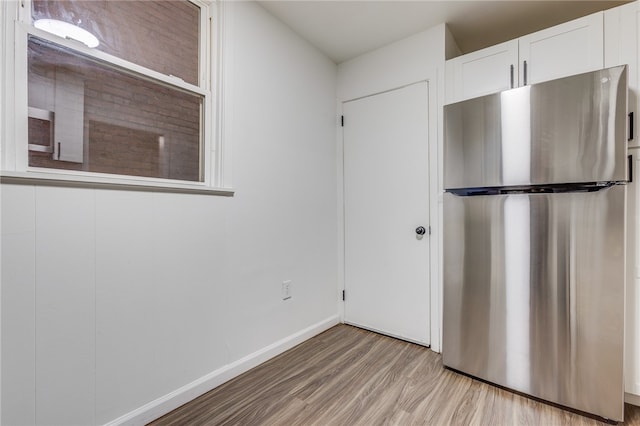 kitchen featuring light hardwood / wood-style flooring, white cabinets, and stainless steel refrigerator