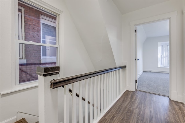 stairs featuring lofted ceiling and hardwood / wood-style flooring