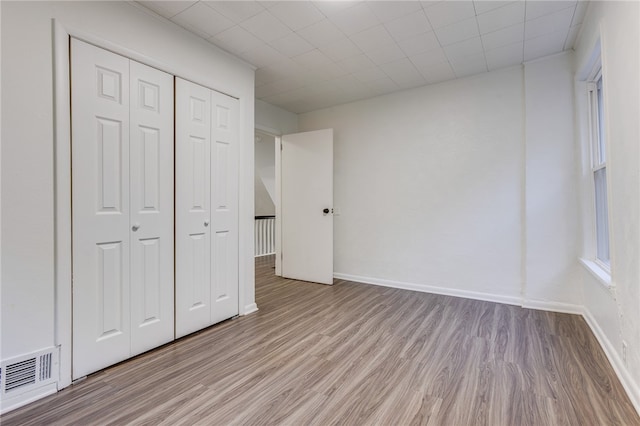 unfurnished bedroom featuring light wood-type flooring and a closet