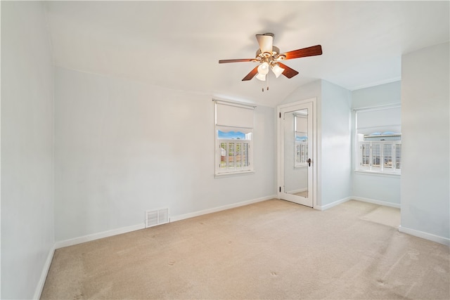 carpeted spare room featuring ceiling fan and lofted ceiling