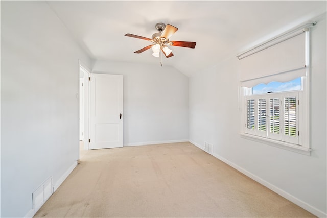 carpeted empty room with vaulted ceiling and ceiling fan