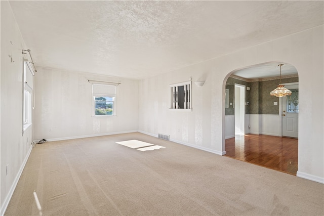 spare room with a textured ceiling, crown molding, and hardwood / wood-style floors