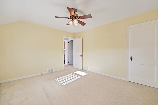 unfurnished bedroom featuring lofted ceiling, light carpet, and ceiling fan