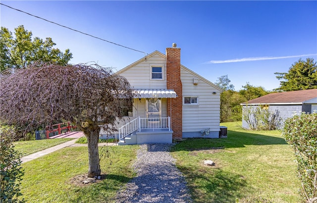 bungalow-style house featuring cooling unit and a front yard