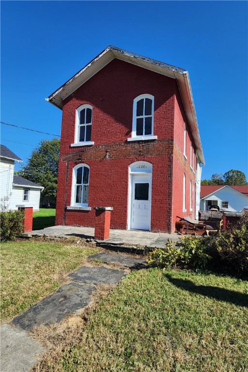 view of front of home with a front yard and brick siding