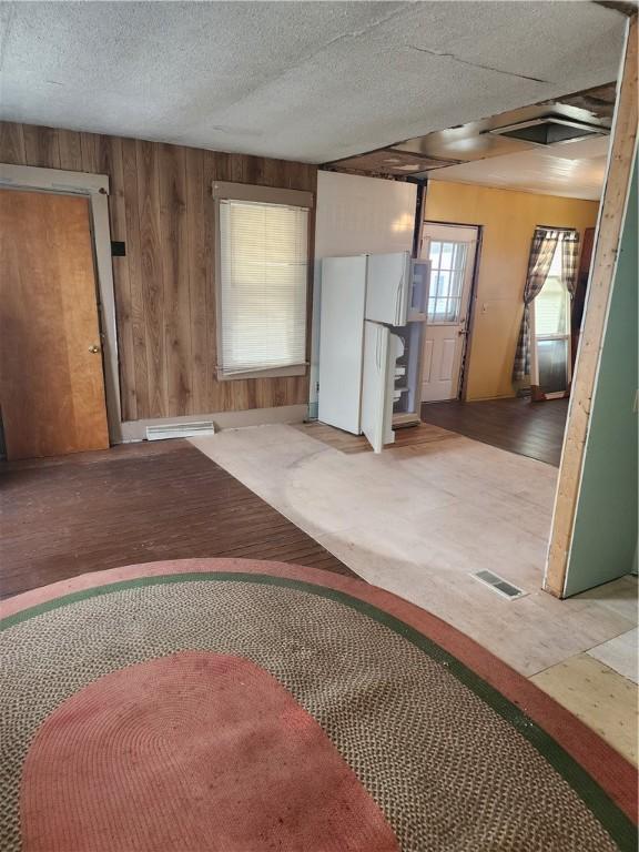 interior space with wood walls, visible vents, and a textured ceiling