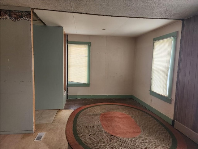 empty room featuring visible vents, baseboards, and wood finished floors