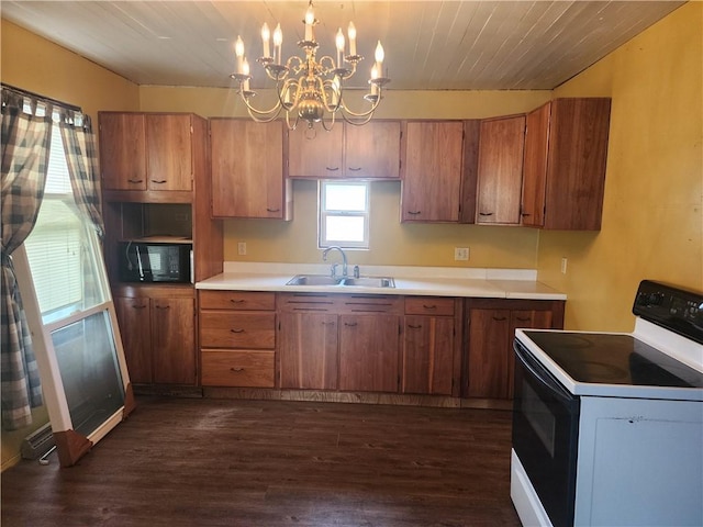 kitchen featuring black microwave, range with electric cooktop, brown cabinets, and a sink