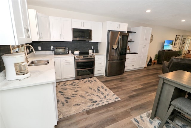 kitchen featuring sink, white cabinets, decorative backsplash, stainless steel appliances, and dark hardwood / wood-style flooring