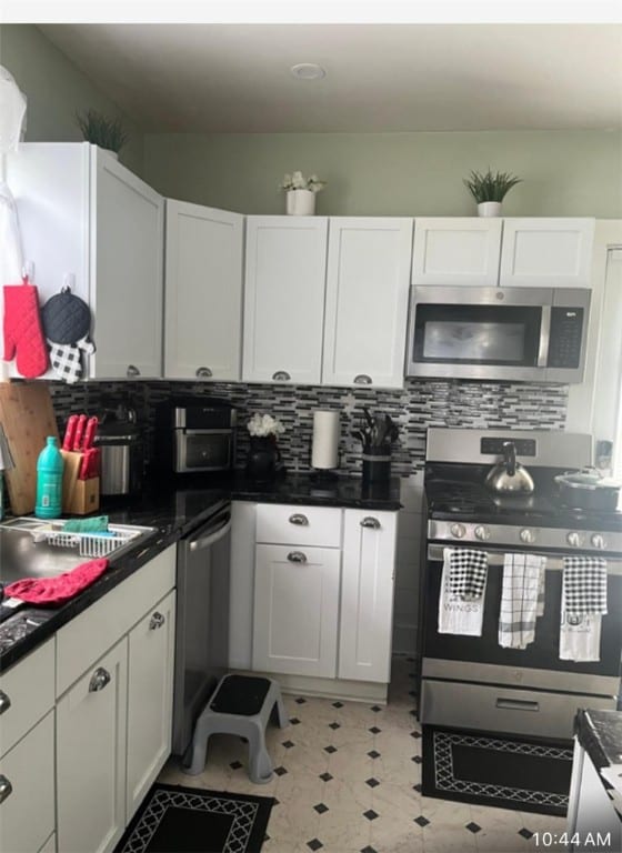 kitchen with sink, white cabinets, stainless steel appliances, and tasteful backsplash