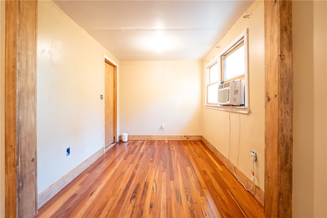 spare room featuring cooling unit and light hardwood / wood-style flooring