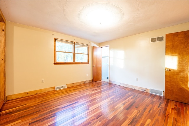 empty room with hardwood / wood-style floors