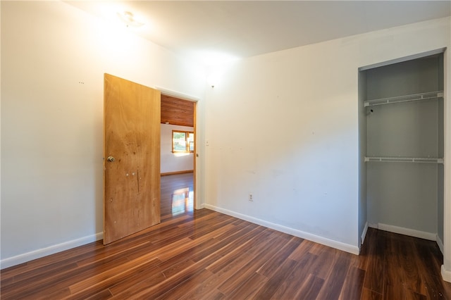 unfurnished bedroom featuring a closet and dark hardwood / wood-style floors