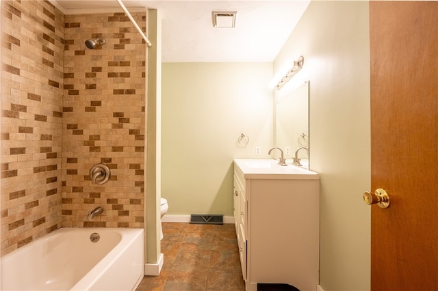 full bathroom featuring tiled shower / bath, vanity, and toilet